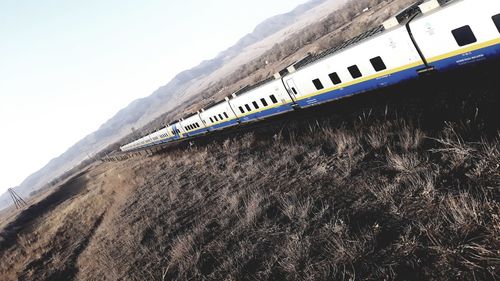 Train on mountain road against sky