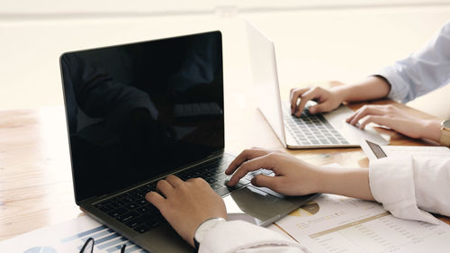 Midsection of man using laptop on table