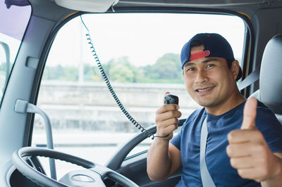 Portrait of smiling man holding car