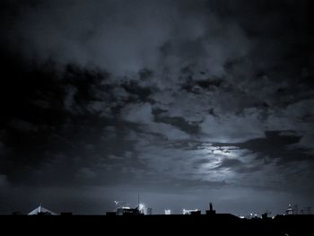 Low angle view of silhouette buildings against sky at night