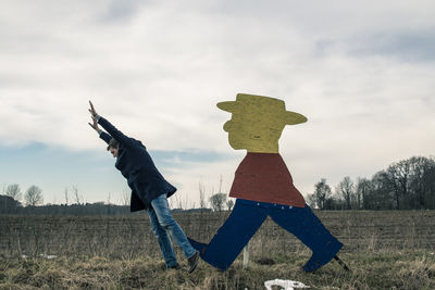 Men standing on field against sky