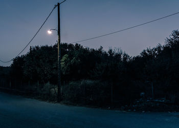 Low angle view of illuminated street lights against sky at night