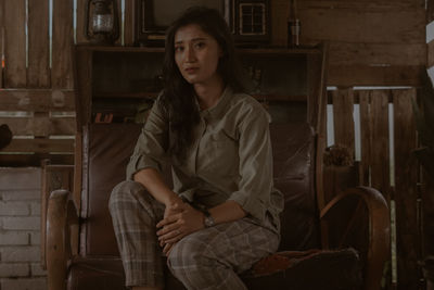 Portrait of young woman sitting on chair