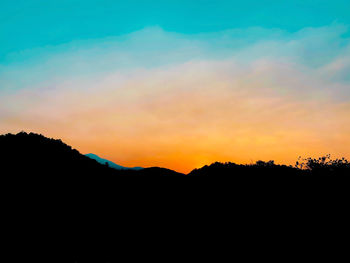 Scenic view of silhouette mountains against sky during sunset