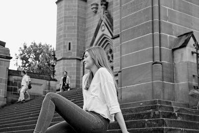 People sitting on staircase of building in city