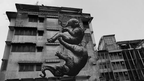 Statue against building in city