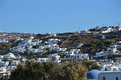 Buildings in city against clear blue sky