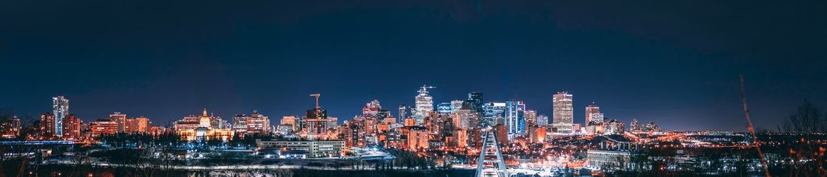 Illuminated buildings in city against sky at night