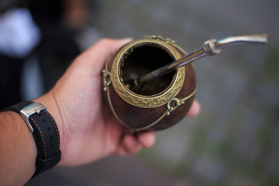 Close-up of mans hand holding small container