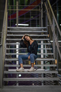 Portrait of smiling young woman sitting on staircase