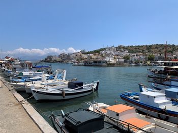 Boats moored in harbor by buildings in city