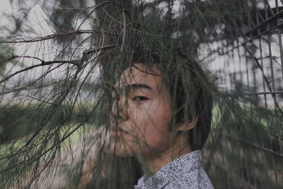 Portrait of young man by branch