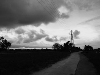 Road passing through landscape against cloudy sky