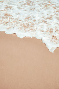 Bubble wave on white sand beach on vacation with a sunny day.