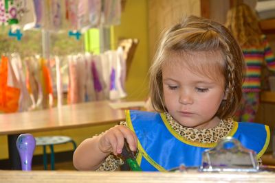 Close-up of girl holding sunglasses on table