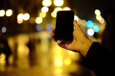 Close-up of person using mobile phone at night