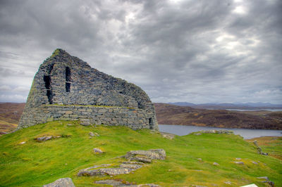 View of castle on mountain against cloudy sky