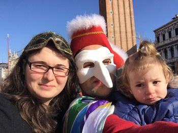 Portrait of man in costume with family standing against st mark campanile