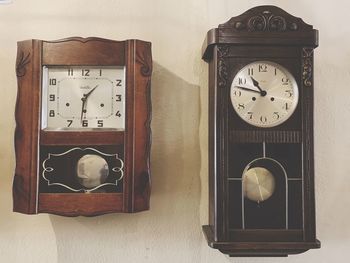 Close-up of clock on table against wall