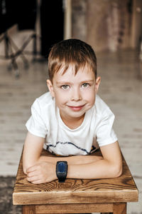 Young little caucasian child with green eyes in a white t-shirt, with a wrist watch,