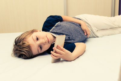 Portrait of girl lying on mobile phone at home