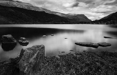 Reflection of rocks in lake against sky