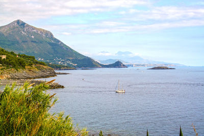 Sailboats in sea against sky