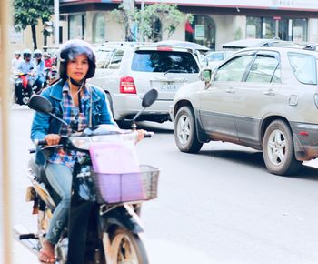 Woman with traffic on road in city