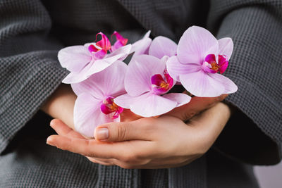 Close-up of hand holding pink flower