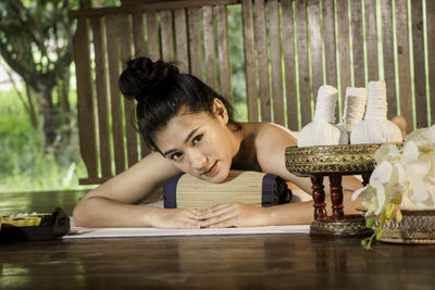 Portrait of young woman sitting on table