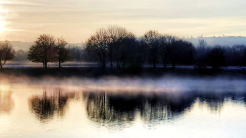 Scenic view of lake against sky at sunset