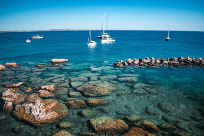 Sailboats on sea against sky