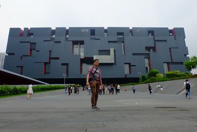 Full length of people walking in city against clear sky