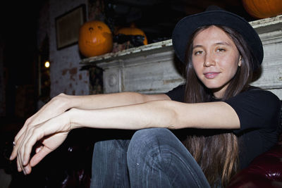 Portrait of young woman sitting in hat