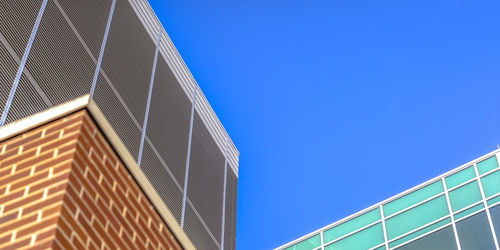 Low angle view of modern building against clear blue sky