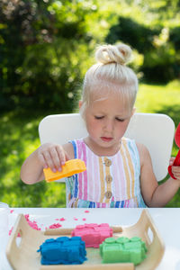 Portrait of girl holding ice cream on table