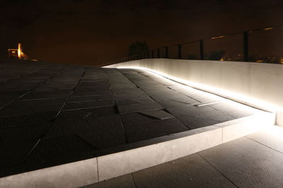 Illuminated road against sky at night