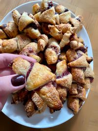 High angle view of hand holding bread in plate