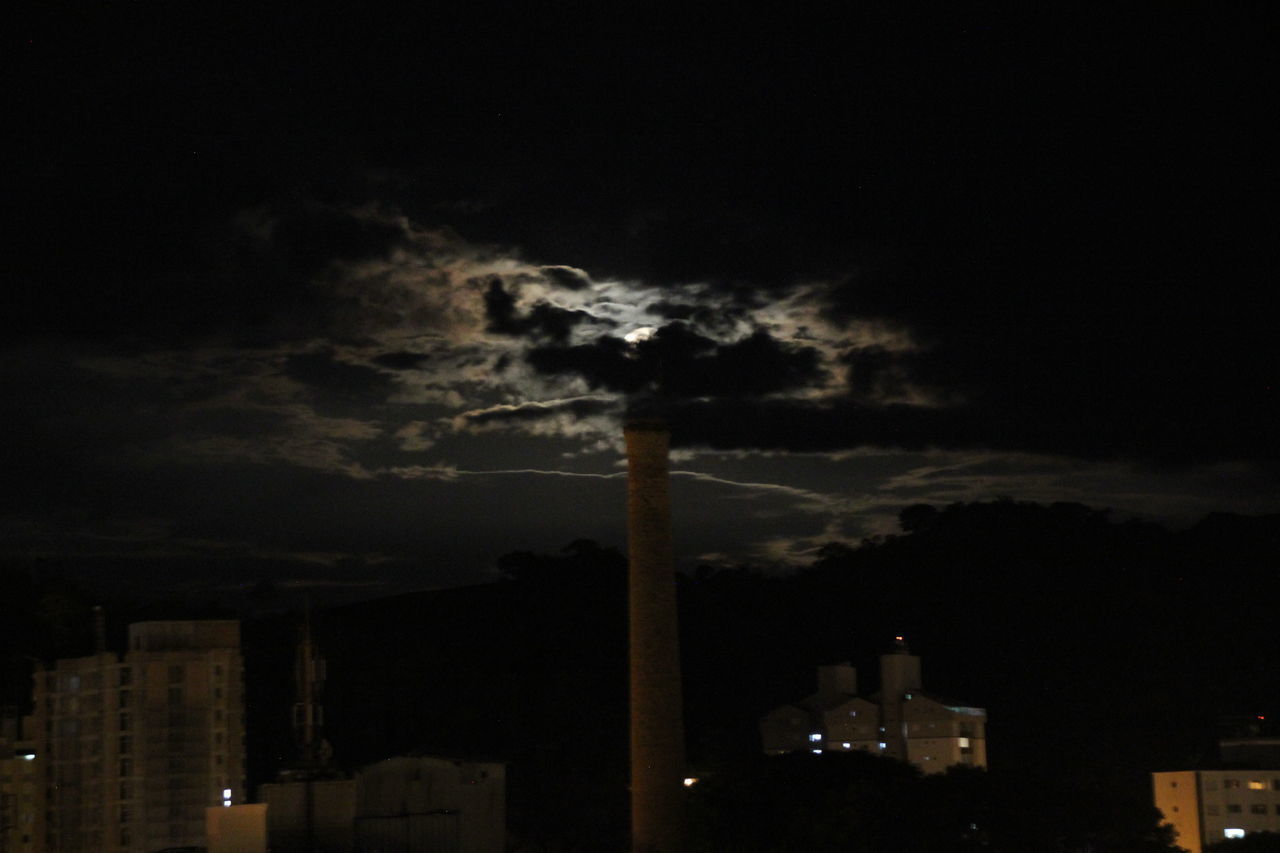 LOW ANGLE VIEW OF ILLUMINATED FACTORY AGAINST SKY