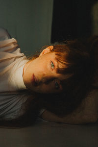 Portrait of young woman lying on floor at home