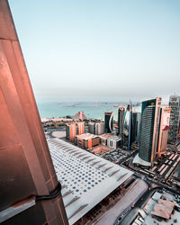 High angle view of sea and buildings against clear sky