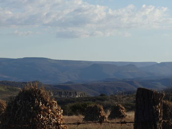 Scenic view of field and mountains against sky