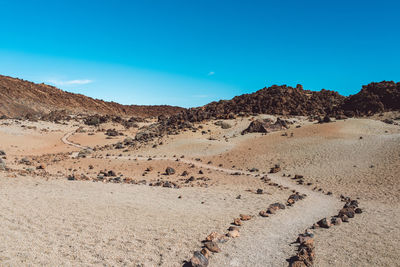 Scenic view of desert against blue sky