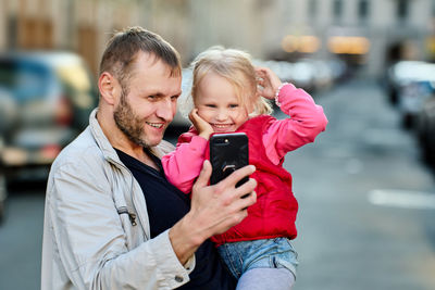 Father showing smart phone to daughter