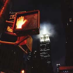 Low angle view of illuminated skyscraper against sky at night