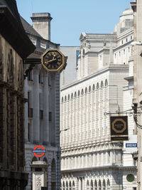 Low angle view of clock tower against buildings in city