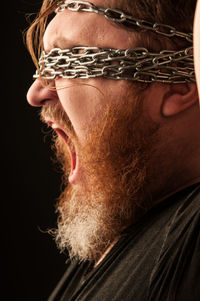 Close-up portrait of man wearing black background