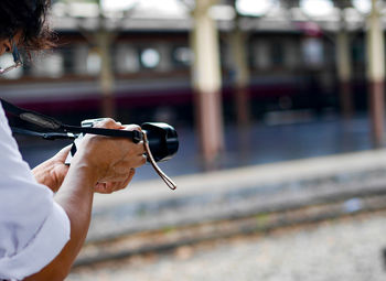 Cropped hand of man photographing outdoors