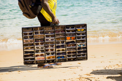 Street vendors walk on the sand of porto da barra beach in salvador, bahia.