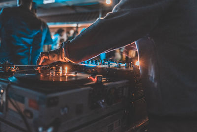 Midsection of man mixing music in recording studio